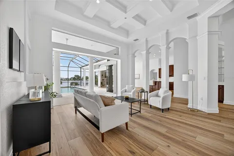 a living room with couches and a large mirror with wooden floor