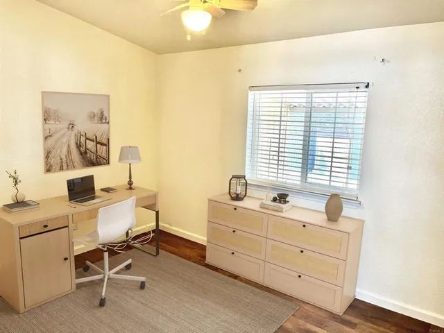a view of a workspace with furniture and a window