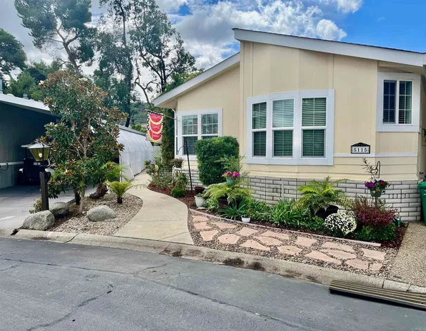 a front view of a house with a yard and potted plants