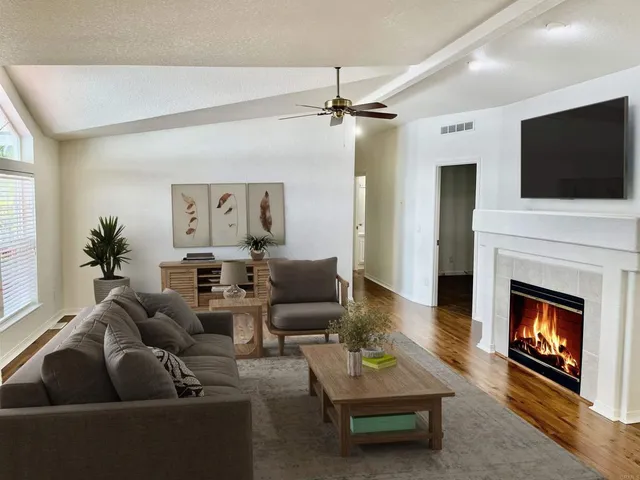 a living room with furniture a flat screen tv and a fireplace