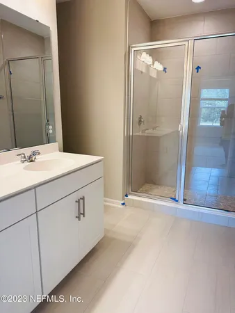 a bathroom with a shower sink and mirror