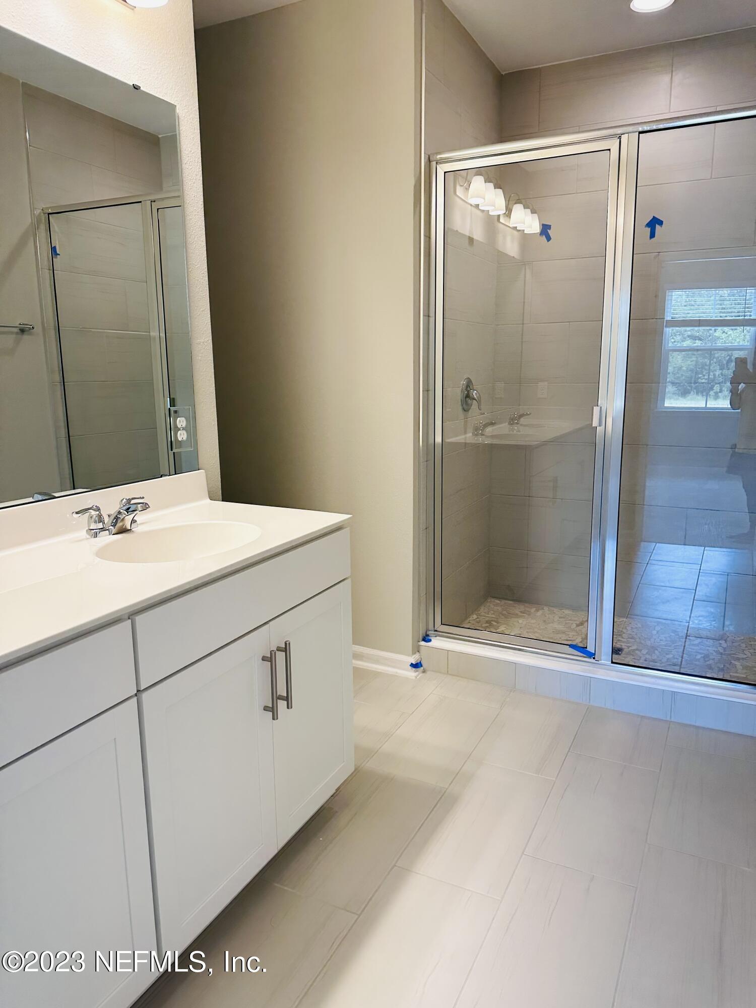 69 Thurnham Lane St. Augustine, FL 32092 - Photo 6 of 10 a bathroom with a shower sink and mirror