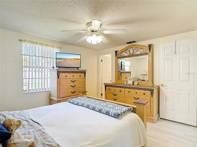 an empty room with wooden floor and chandelier fan