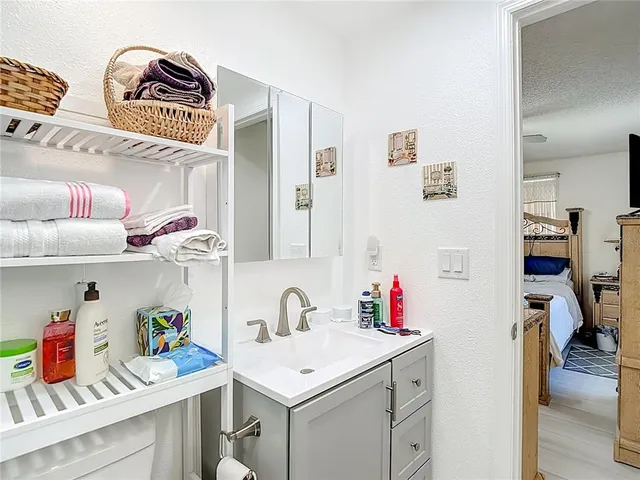 a bathroom with a toilet sink vanity and mirror