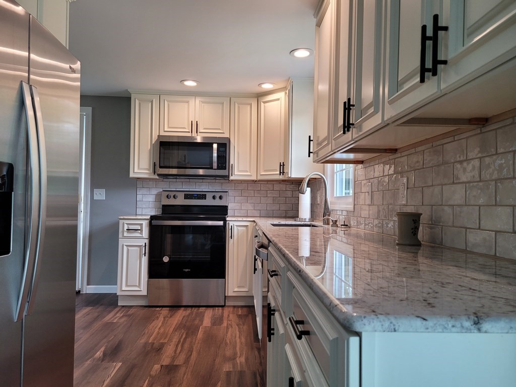 416 Southampton Road Holyoke, MA 01040 - Photo 4 of 12 a kitchen with stainless steel appliances granite countertop a stove a sink and a refrigerator