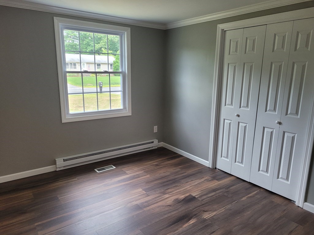 416 Southampton Road Holyoke, MA 01040 - Photo 8 of 12 an empty room with wooden floor and windows