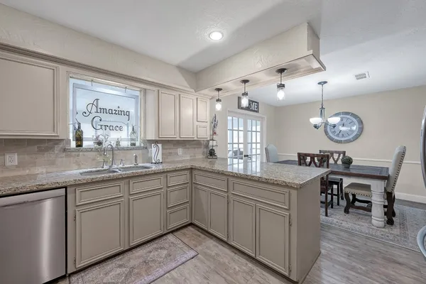 a kitchen with granite countertop cabinets stainless steel appliances and a sink