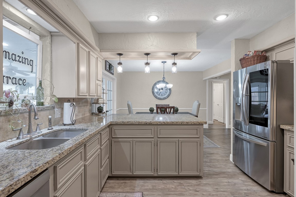 8 Cambridge Road Conroe, TX 77304 - Photo 16 of 44 a kitchen with stainless steel appliances granite countertop a sink and a refrigerator