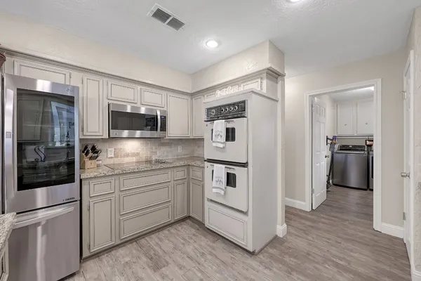 a kitchen with stainless steel appliances granite countertop a sink and a refrigerator
