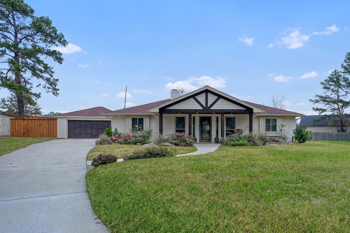8 Cambridge Road Conroe, TX 77304 - Photo 2 of 44 a front view of a house with a yard and garage