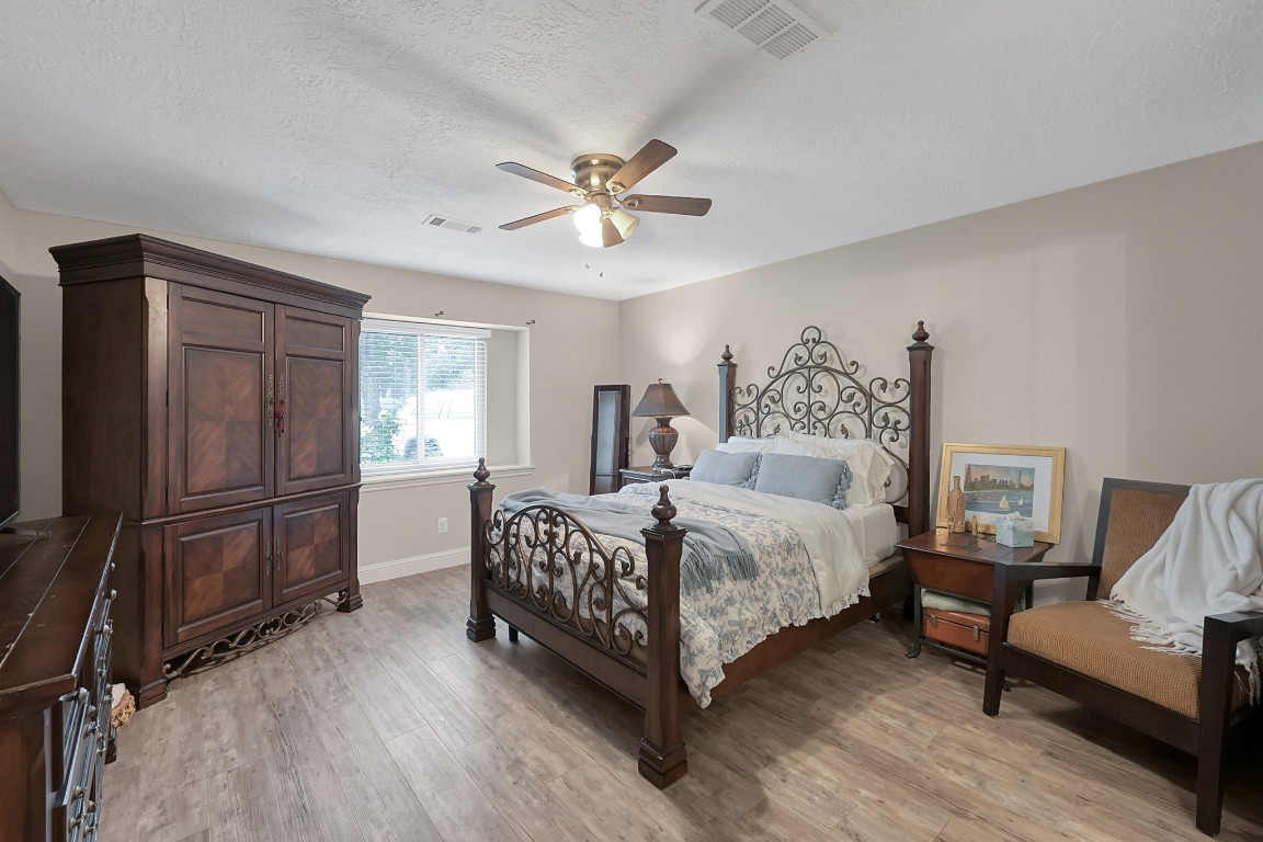 8 Cambridge Road Conroe, TX 77304 - Photo 21 of 44 a bedroom with a bed couch and a window