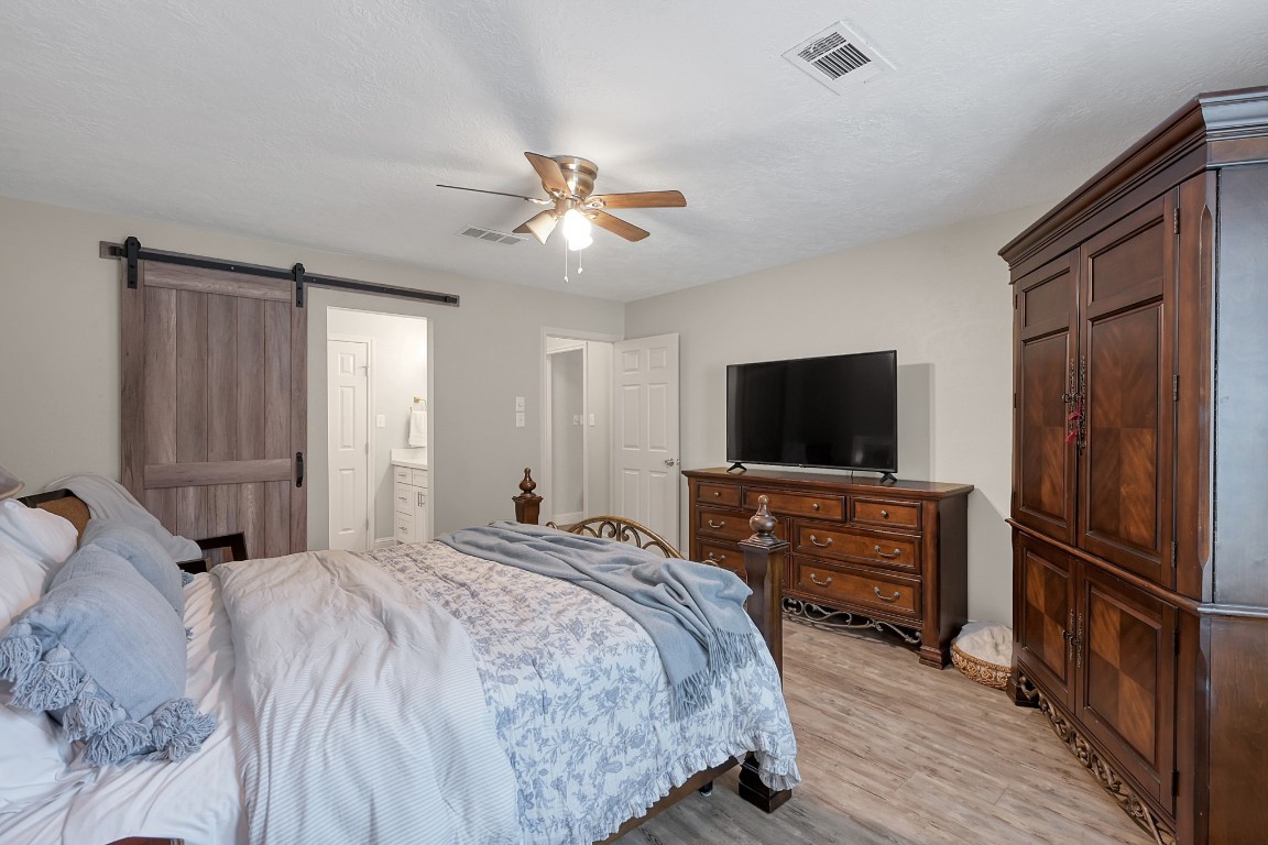 8 Cambridge Road Conroe, TX 77304 - Photo 23 of 44 a bedroom with a bed and a flat screen tv