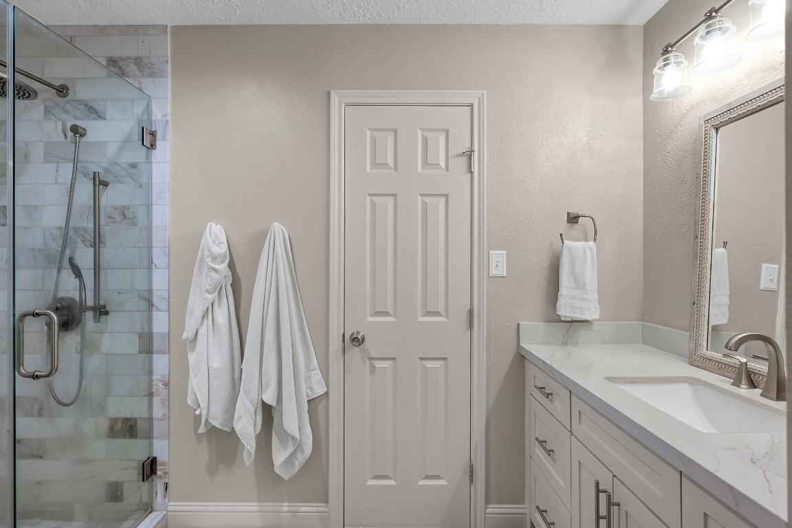 8 Cambridge Road Conroe, TX 77304 - Photo 24 of 44 a bathroom with a double vanity sink a mirror and shower