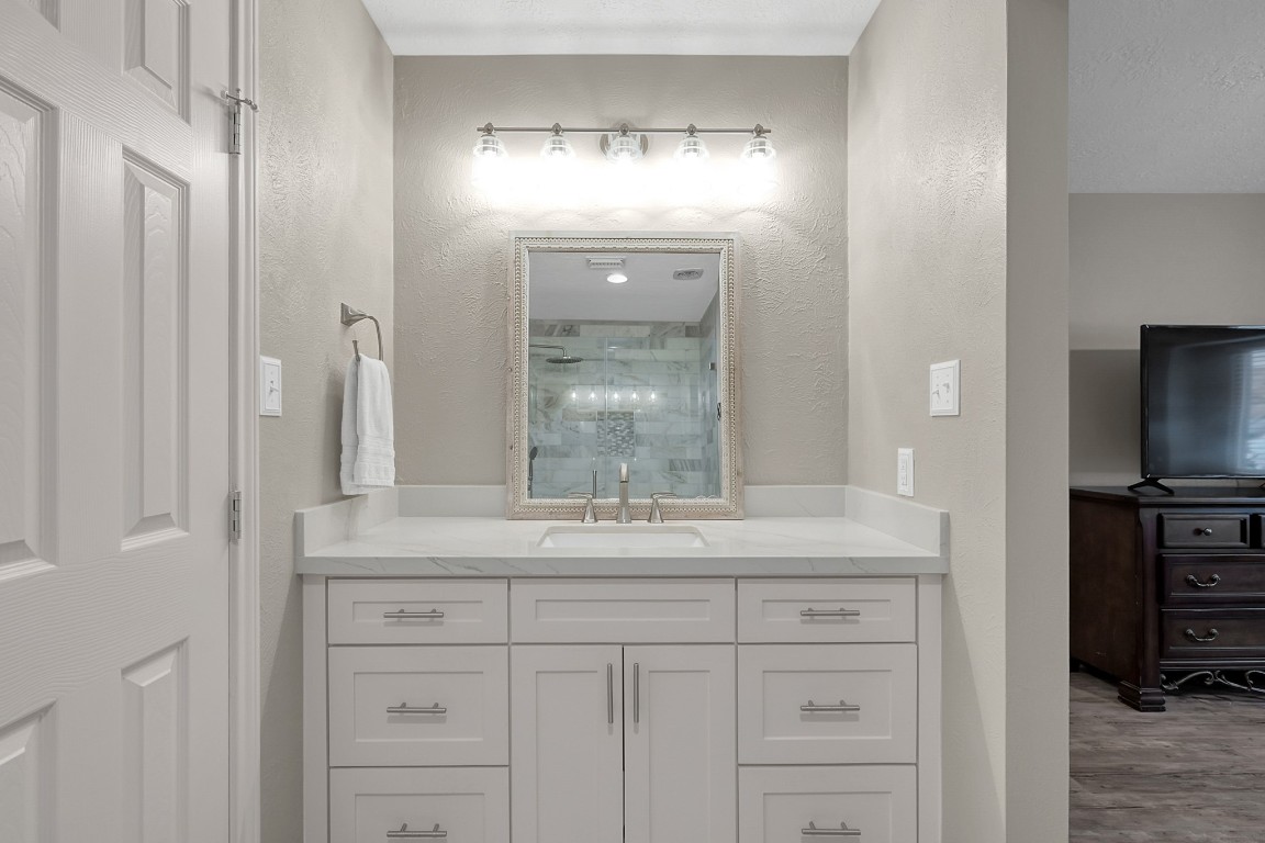 8 Cambridge Road Conroe, TX 77304 - Photo 25 of 44 a bathroom with a granite countertop sink a mirror and a shower
