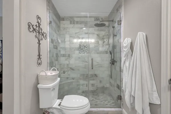 a bathroom with a granite countertop sink a mirror and a shower
