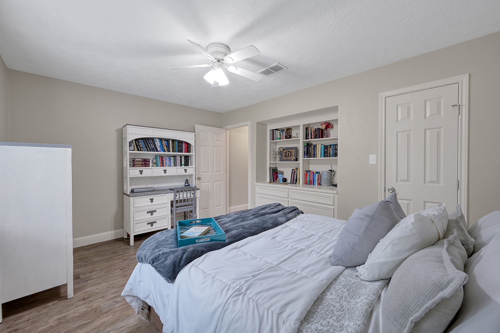 8 Cambridge Road Conroe, TX 77304 - Photo 28 of 44 a bedroom with a bed and a chandelier