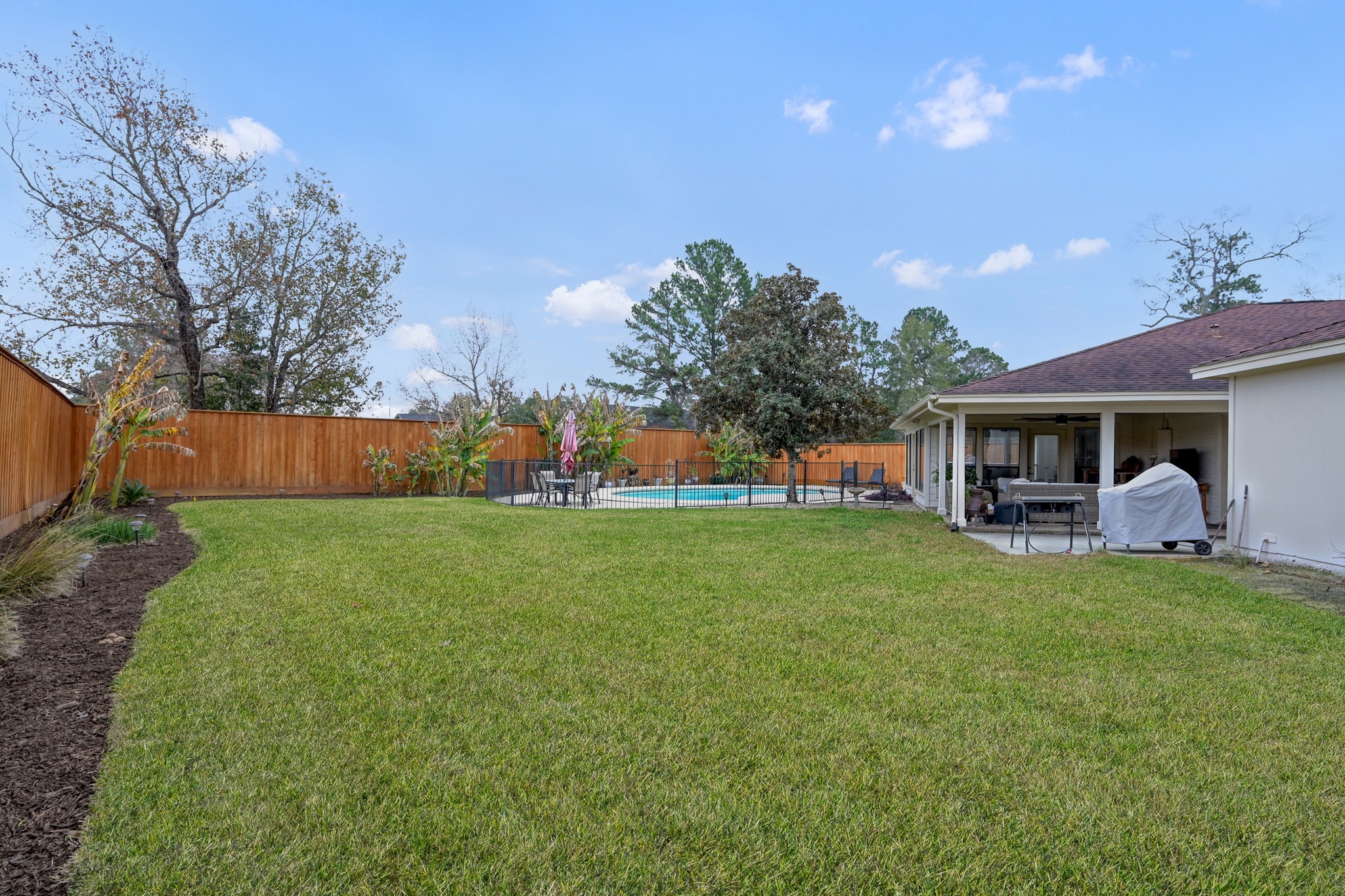 8 Cambridge Road Conroe, TX 77304 - Photo 37 of 44 a front view of a house with a garden and plants