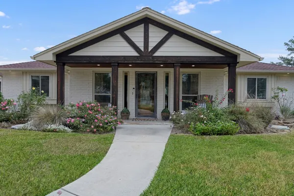 a front view of a house with a garden and plants