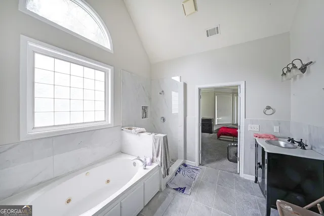 a bathroom with a tub sink and a mirror