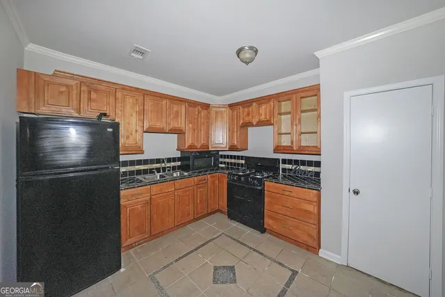 a kitchen with stainless steel appliances granite countertop a refrigerator and a stove