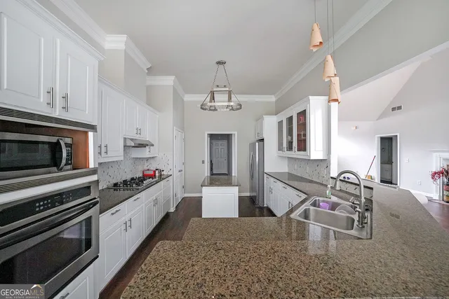 a kitchen with sink stove and cabinets