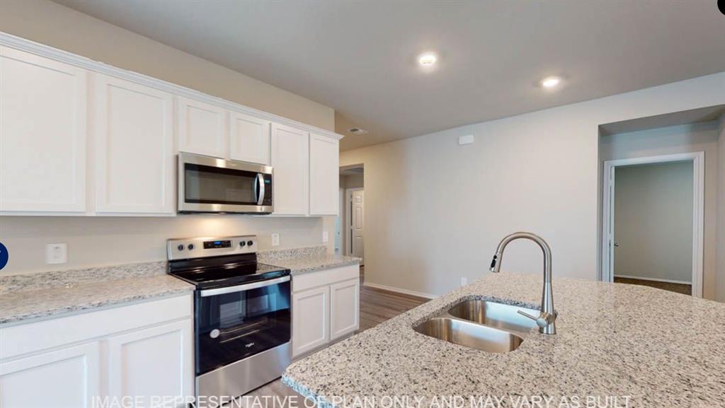 10204 Neptune Court Waco, TX 76708 - Photo 2 of 20 Modern kitchen featuring white cabinetry, stainless steel appliances, and light-colored countertops