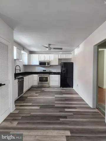 a view of kitchen with refrigerator and cabinets