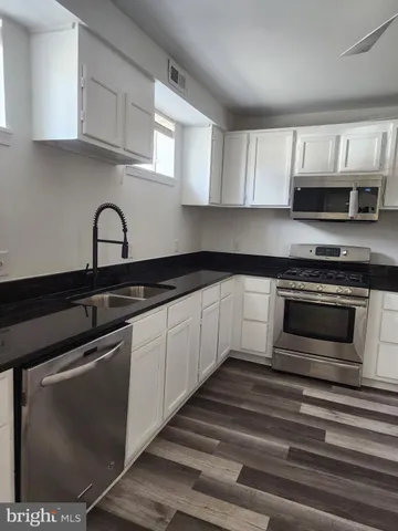a kitchen with granite countertop a stove and a sink