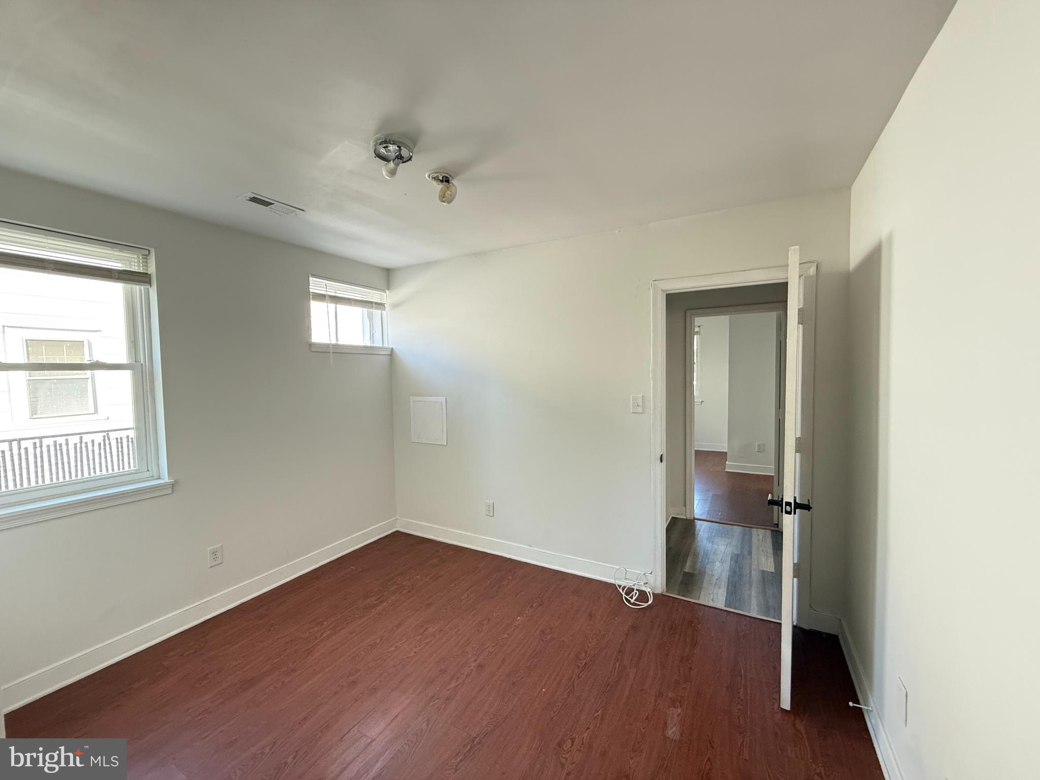 606 Stuart Street, Unit 1 Fredericksburg, VA 22401 - Photo 7 of 13 an empty room with wooden floor and windows