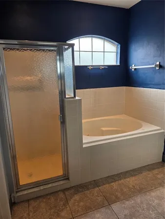 a bathroom with bathtub next to a window