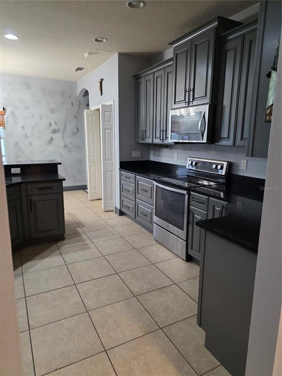 2850 Sheldon Street Lakeland, FL 33813 - Photo 18 of 23 a kitchen with stainless steel appliances granite countertop a stove a sink and a microwave