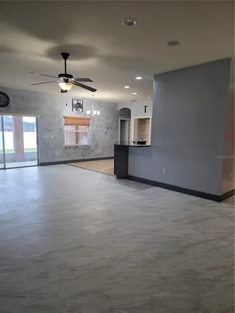 an empty room with windows and cabinet