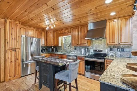 a kitchen with granite countertop a sink a stove and cabinets