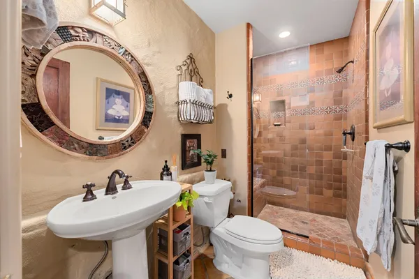 a bathroom with a sink a toilet and shower