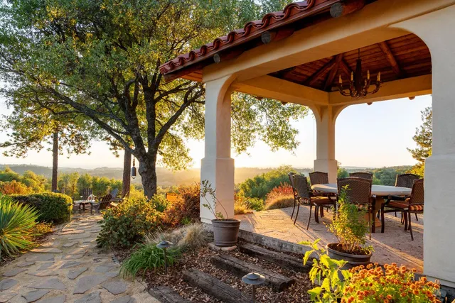 a view of a roof deck with couches under an umbrella