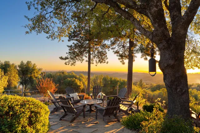 a view of a chairs and table in the patio in front of a house
