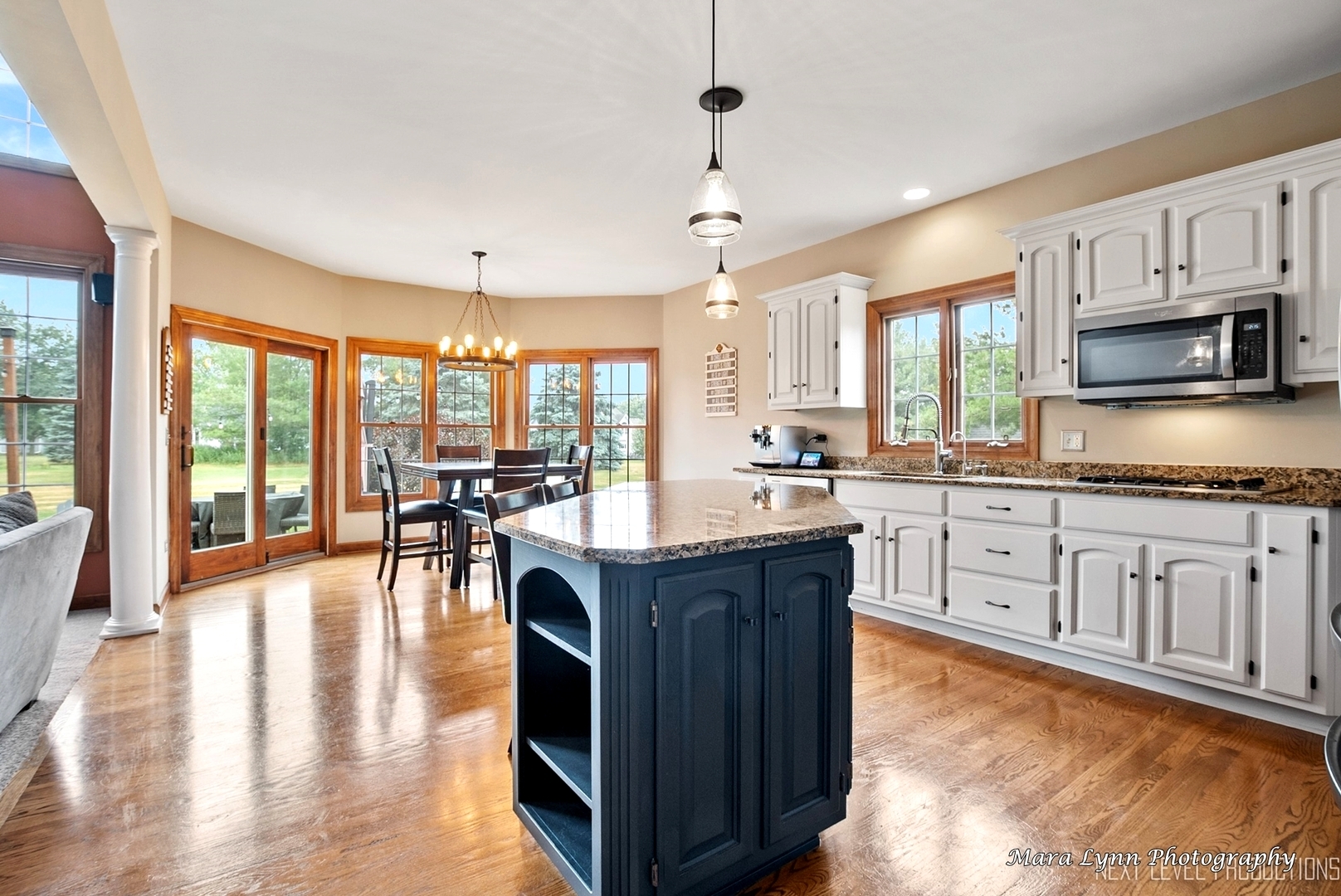 7N265 Ridge Line Road St. Charles, IL 60175 - Photo 7 of 46 a kitchen with granite countertop a stove a sink a dining table and chairs with wooden floor