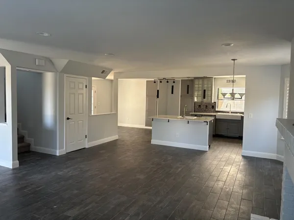 a view of a kitchen with refrigerator stove and wooden floor