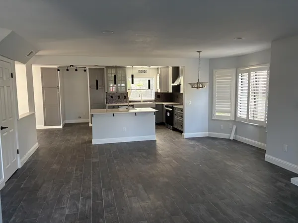 a large kitchen with a sink stainless steel appliances and cabinets