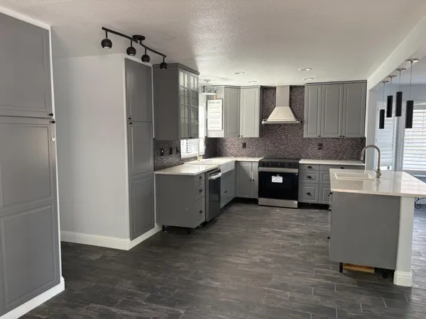 a kitchen with stainless steel appliances granite countertop a sink refrigerator and cabinets