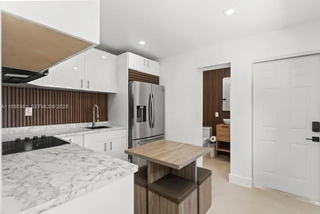 a kitchen with stainless steel appliances kitchen island a refrigerator sink and stove