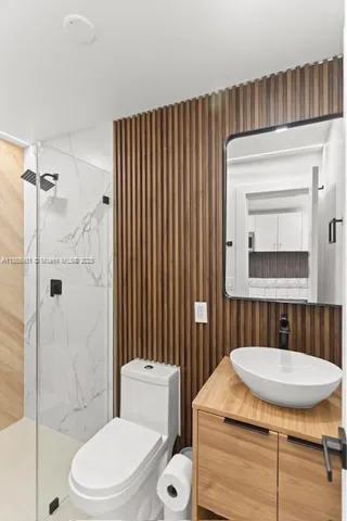 a bathroom with a sink toilet a mirror and shower