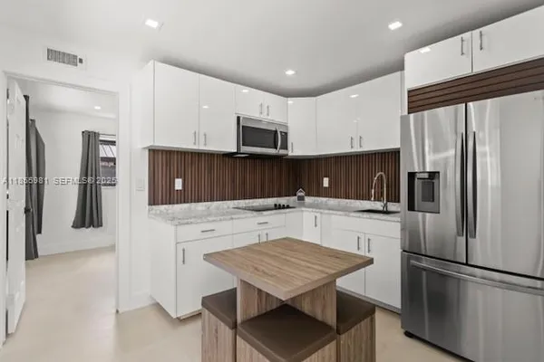 a kitchen with a refrigerator a stove a microwave and cabinets
