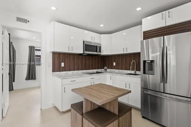 a kitchen with a refrigerator a stove a microwave and cabinets