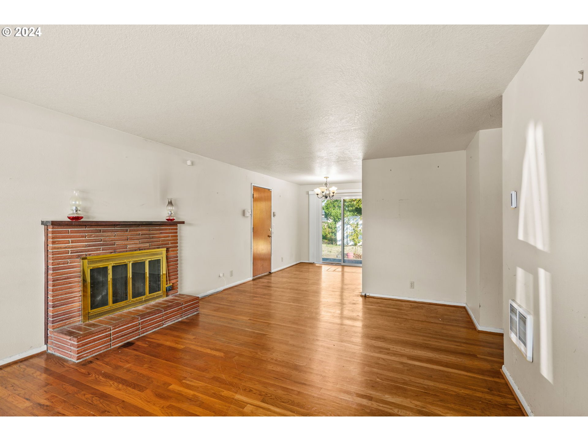 1416 Quinalt Street Springfield, OR 97477 - Photo 6 of 24 a view of empty room with wooden floor and fireplace