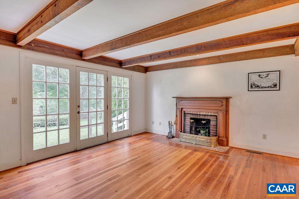 674 Gillums Ridge Road Charlottesville, VA 22903 - Photo 18 of 50 a view of an empty room with wooden floor fireplace and a window