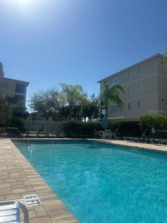 940 Cooper Street, Unit 302 Venice, FL 34285 - Photo 2 of 28 a view of a swimming pool with a yard