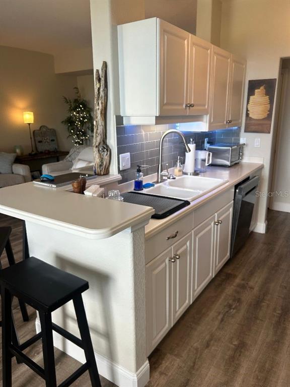 940 Cooper Street, Unit 302 Venice, FL 34285 - Photo 8 of 28 a kitchen with a sink a stove and chairs