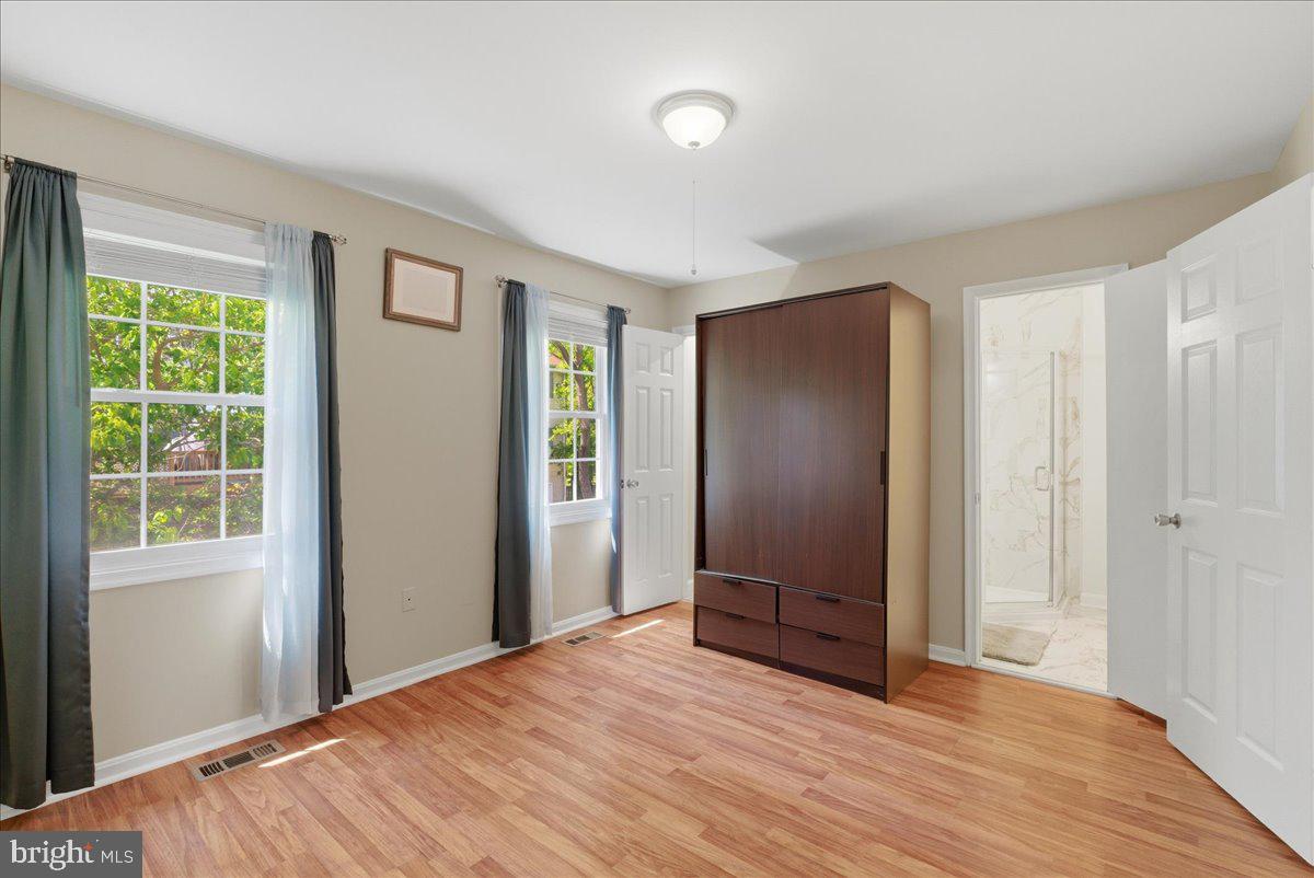 8582 Adamson Street Manassas, VA 20110 - Photo 16 of 24 a view of an empty room with wooden floor and a window