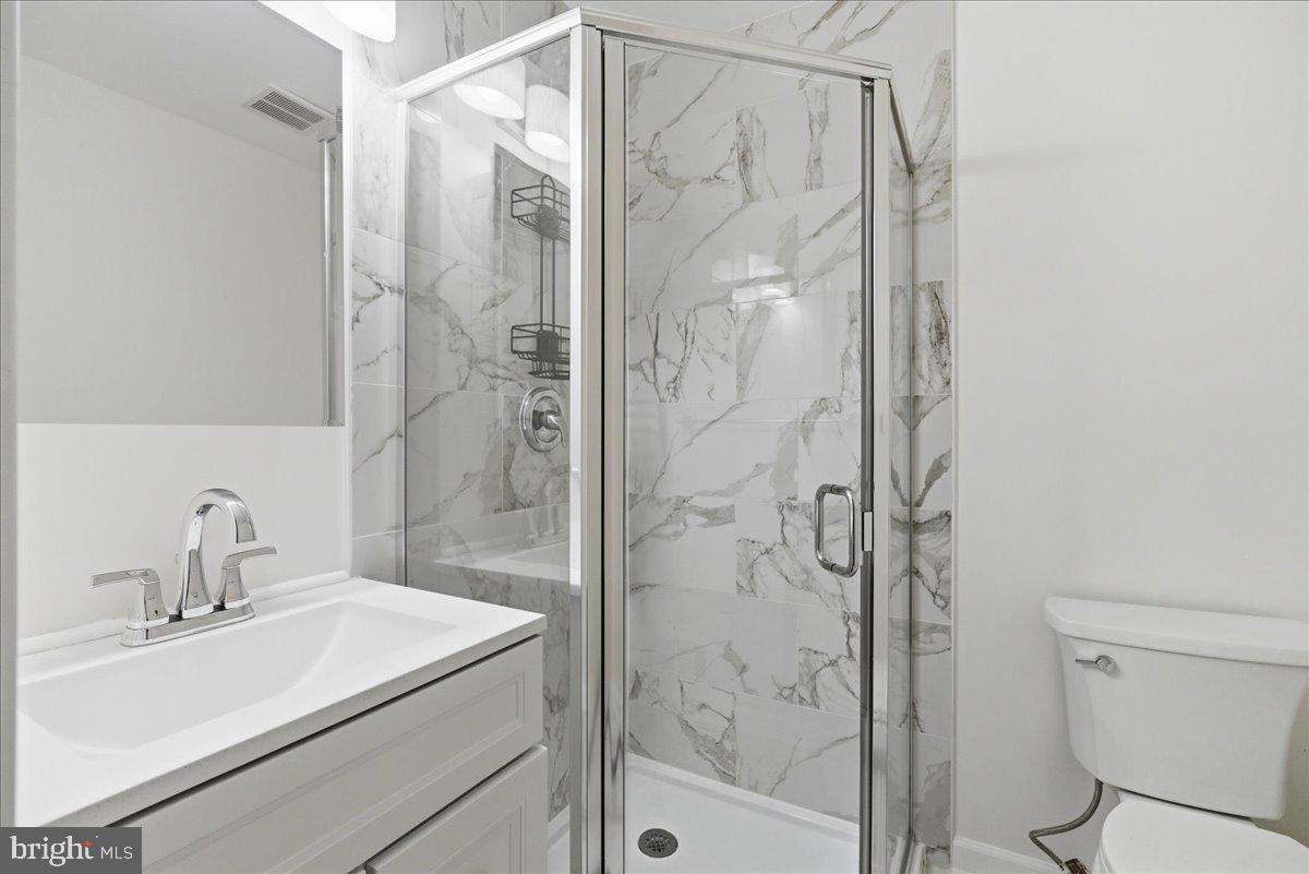 8582 Adamson Street Manassas, VA 20110 - Photo 18 of 24 a bathroom with a shower curtain a sink and a mirror